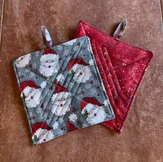 two quilted christmas coasters sitting on top of a floor next to each other