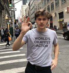 a young man is making the vulcan sign while crossing the street in new york city