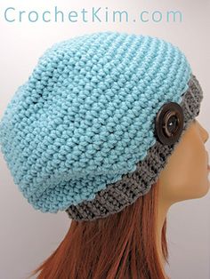 a crocheted hat with buttons on the front and side, sitting on top of a mannequin head