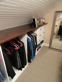 a closet with clothes hanging on the wall