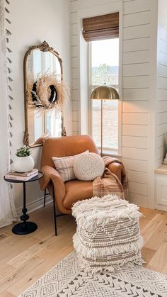 a living room filled with furniture and a mirror on the wall next to a window