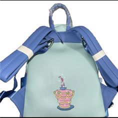 a small blue backpack with a cartoon character on the front and back pocket, attached to a shoulder strap