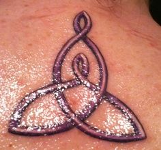 a woman's neck with a tattoo design on the back of her neck,