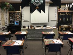 an empty classroom with desks and chairs in front of a projector screen on the wall