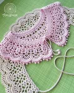 two crocheted doily are laying on a green surface