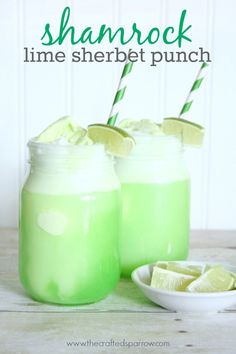 two mason jars filled with lime sherbet punch on top of a wooden table