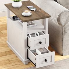 a small table with drawers in front of a couch and coffee cup on the side