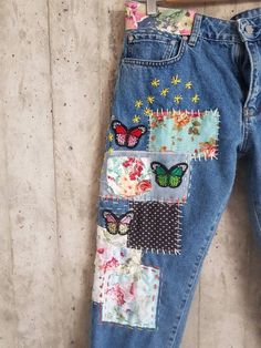 a pair of jeans with patches and butterflies on them