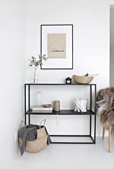 a shelf with baskets and other items on it in a room that has white walls