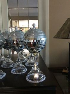 several wine glasses sitting on top of a table with disco balls in the middle of them