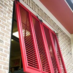 red shutters on the side of a brick building