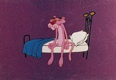 a pink monkey sitting on top of a bed next to a night stand and lamp