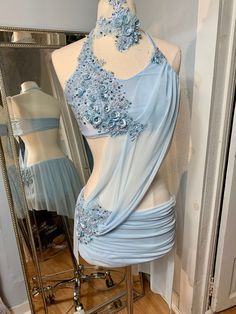 a mannequin with a dress on it in front of a mirror