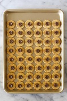 a cookie sheet covered in mini donuts and chocolates on a marble counter top