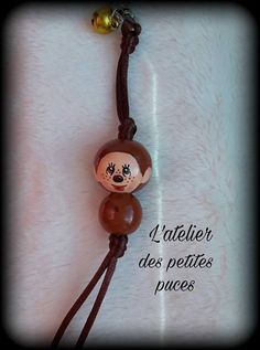 a necklace with a monkey on it and beads attached to the end of each bead