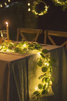 the table is set with candles and greenery