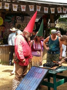 a group of people standing around a table with a solar panel on top of it