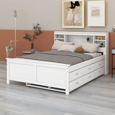 a white bed sitting in a bedroom next to a wooden floor