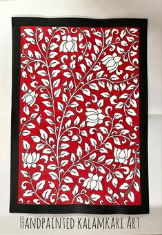 an intricately designed red and black cloth with white flowers on the border is displayed