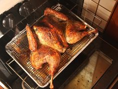 chicken cooking in an oven on a wire rack