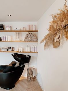 a hair salon with shelves filled with bottles and items on the wall next to it