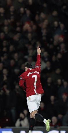 a soccer player is jumping in the air with his arms up and legs spread wide