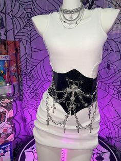 Elevate your style with this edgy Y2K-inspired corset belt, featuring a captivating punk aesthetic. Adorned with intricate cross charms and a bold heart design, this statement piece effortlessly combines rebellious flair with a touch of romance. The belt is enhanced with eye-catching chains that add an extra layer of attitude. Crafted for comfort and versatility, the back of the corset belt is equipped with a convenient Velcro closure. The elastic material provides just the right amount of stret Gothic Corset With Belt For Cosplay, Punk Party Corset, Edgy Festival Corset For Halloween, Edgy Halloween Festival Corset, Halloween Corset For Concert, Gothic Chain Belt For Party, Gothic Corset Belt For Party, Edgy Black Chain Belt For Festival, Punk Black Corset Belt For Halloween