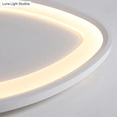 a white circular light fixture with dim lighting on the top and below it's surface