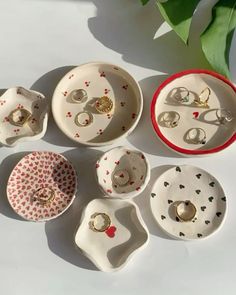 seven pieces of porcelain jewelry sitting next to each other on top of a white table