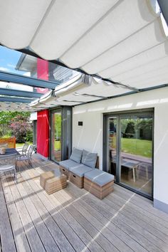 an outdoor deck with furniture and large sliding glass doors that open up to the backyard