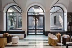 the lobby is decorated in black and white with large arched windows on either side of it