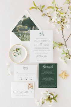 the wedding stationery is laid out on top of an envelope and some white flowers