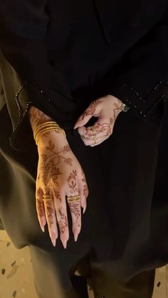 a woman's hands with hennap and bracelets on her left hand