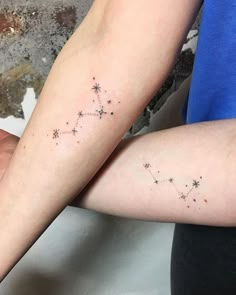 two people with tattoos on their arms, one is holding the other's arm