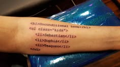 a person with a tattoo on their arm that has words in different languages written across it