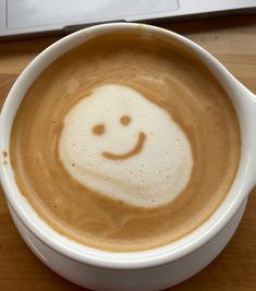 a cup of coffee with a smiley face drawn on it