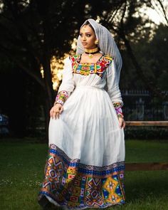 This Habesha dress is a true masterpiece of Ethiopian fashion that combines the beauty of Menen fabric with a colorful and vibrant Tilf design. The Menen fabric adds a touch of luxury and elegance to the dress, while the Tilf design adds a unique and traditional touch. The dress is breathtaking and eye-catching, with a flattering and comfortable fit that accentuates the beauty of the wearer. The colorful pattern Tilf design on the dress is intricate and beautiful, a testament to the skill and cr Eritrean Women, Habesha Clothes, Ethiopian Wedding Dress, Candle Pics, Habesha Wedding, Ethiopian Orthodox Church, Eritrean Clothing, Ethiopian Dresses, Ethiopian People