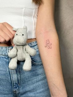 a small tattoo on the back of a woman's left arm shows a teddy bear