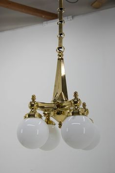 three light chandelier with white glass balls hanging from it's ceiling fixture