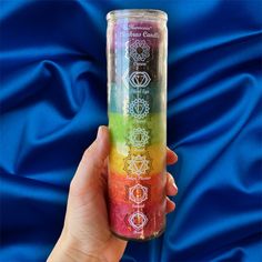 a hand holding a glass with seven chakras on it and the colors of the rainbow