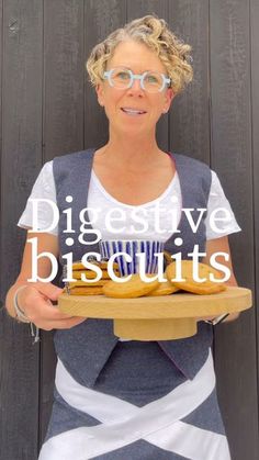 a woman holding a plate with some food on it and the words digest biscuits above her