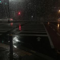 an empty crosswalk in the rain at night