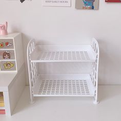 there is a white shelf with pictures on the wall next to it and a toy refrigerator