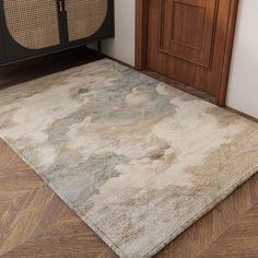 an area rug is placed on the floor in front of a wooden cabinet and door