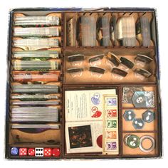 an open box filled with lots of different types of cards and dices on top of each other