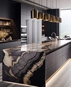 a large kitchen with marble counter tops and black cabinets, along with gold pendant lights hanging from the ceiling