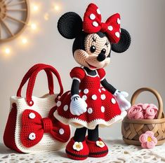 a crocheted minnie mouse doll next to a handbag and purse on a table