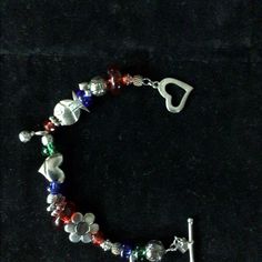 a bracelet with charms on it sitting on a black surface