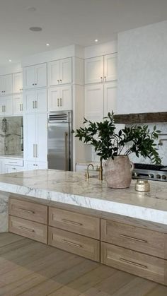 a large kitchen with marble counter tops and wooden floors