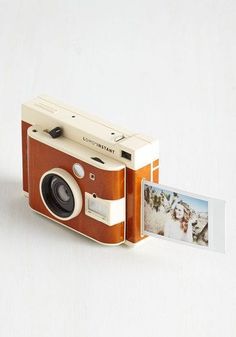 an old fashioned camera with a polaroid print on the front and side, attached to a card holder